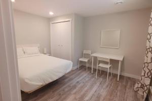 a bedroom with a bed and a table and chairs at Beautiful 2 bedroom + office basement suite in Calgary