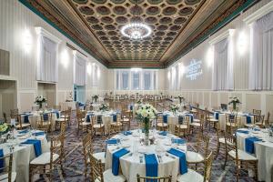 um salão de banquetes com mesas e cadeiras com lençóis azuis e brancos em Gettysburg Hotel em Gettysburg