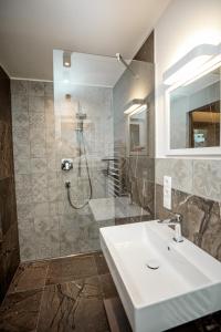 a bathroom with a sink and a shower at Tyrol Living & Cafe in Nova Levante