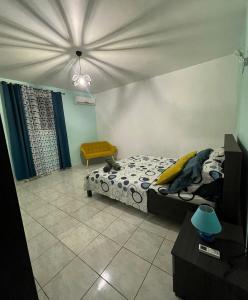 ein Schlafzimmer mit einem Bett und einem Stuhl darin in der Unterkunft Villa de L'anse - bas de villa in Vieux-Habitants