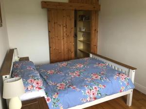 a bed with a blue comforter with flowers on it at Skellig View in Portmagee