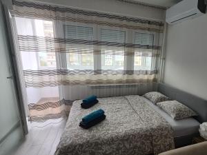 a bedroom with two pillows on a bed with a window at ADA View apartment in Belgrade