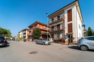 due auto parcheggiate sul lato di una strada con edifici di Shiny Home Verona a Verona