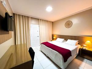 um quarto de hotel com uma cama e uma mesa em Pousada Maresia em São Miguel dos Milagres