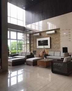 eine Lobby mit Sofas und Tischen in einem Gebäude in der Unterkunft A&B Condo with Netflix at SMDC Wind Residences in Tagaytay