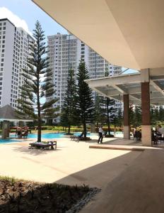 park z drzewami, ławkami i wysokimi budynkami w obiekcie A&B Condo with Netflix at SMDC Wind Residences w mieście Tagaytay