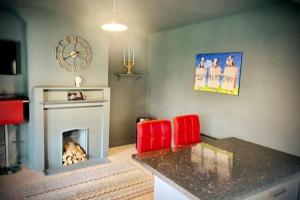 a living room with two red chairs and a fireplace at 3 Bedroom House -Sleeps 6- Big Savings On Long Stays! in Canterbury