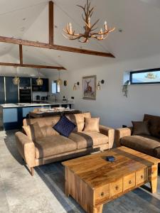 uma sala de estar com dois sofás e uma mesa de centro em The Potting Shed em Bredon
