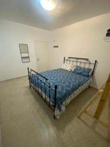 a bedroom with a bed with a blue comforter at Hoeny home in Bat Yam