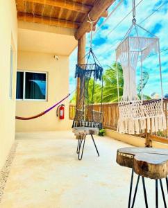 a porch with a hanging swing and a table at Corazon Mexicano Holbox in Holbox Island