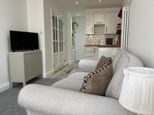 a living room with a couch and a television at St Annex, Boutique Holiday Apartment for 2 people in Torquay - with Private HOT TUB! in Torquay