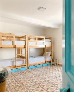 a room with bunk beds in a hostel at El MOJA SURFHOUSE in Sidi Ifni