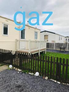 a house with a fence and a sign that says c z at Gaz goldengates in Kinmel Bay