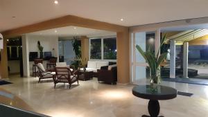 Vallclaire Suites في بارانكويلا: غرفة معيشة مع أريكة وكراسي وطاولة