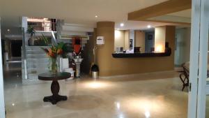 a lobby with a vase of flowers on a table at Vallclaire Suites in Barranquilla