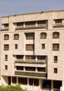 a large white building with windows at Shanasheel Palace Hotel in Baghdād