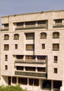un gran edificio blanco con ventanas en Shanasheel Palace Hotel, en Baghdād