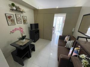 a living room with a couch and a tv at A&B Condo with Netflix at SMDC Wind Residences in Tagaytay