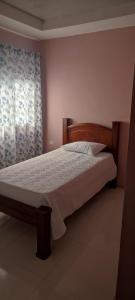 1 dormitorio con cama de madera y ventana en Pura vida apartament 5 min near aiport NO PARKING SITE, en Alajuela
