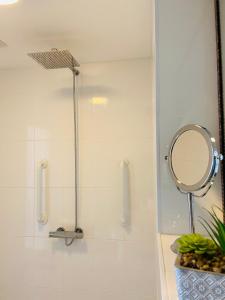 ein Bad mit einer Dusche und einem Spiegel in der Unterkunft Above the Bay - Enclosed garden apartment with parking in Penzance + 13 Fotos