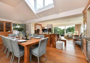 a kitchen and living room with a wooden table and chairs at Gwêl y Môr in Abersoch