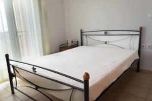 Modern vacation house near Ermioni في Loukaḯtion: سرير بإطار معدني وشراشف بيضاء