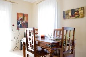 uma sala de jantar com uma mesa de madeira e cadeiras em Villa Iolis em Lefkada