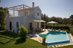 a villa with a swimming pool in front of a house at Villa Iolis in Lefkada