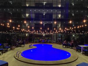 una gran piscina azul en un edificio con luces en Hotel Ciudad de David, en David