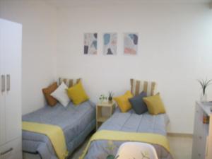 dos camas sentadas una al lado de la otra en un dormitorio en Monoambiente en Caballito para 2 personas en Buenos Aires