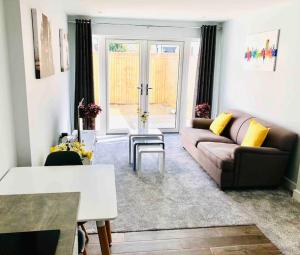a living room with a couch and a table at Centrally situated house plus private parking in Cheltenham