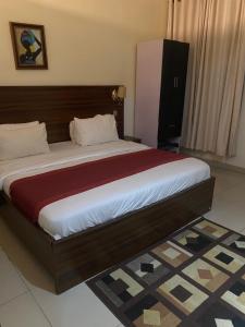 a bedroom with a large bed with a wooden headboard at Posh Hotel and Suites Victoria Island in Lagos