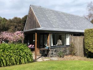 una pequeña casa con techo gris en Tranquil Family Retreat, en Akaroa