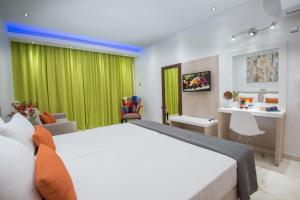 1 dormitorio con 1 cama grande y cortina verde en Loutsiana Deluxe Apts en Ayia Napa