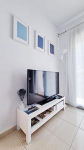 ein Wohnzimmer mit einem TV in einem weißen Unterhaltungszentrum in der Unterkunft Costa Brava-St Antoni de Calonge apartament per parelles i famílies petites in Calonge