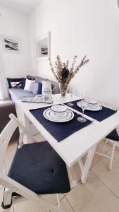 einen weißen Esstisch mit blauer Serviette in der Unterkunft Costa Brava-St Antoni de Calonge apartament per parelles i famílies petites in Calonge