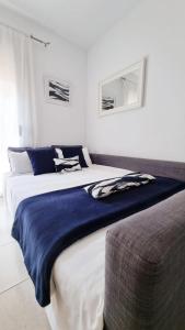 ein Schlafzimmer mit einem großen Bett mit einer blauen Decke in der Unterkunft Costa Brava-St Antoni de Calonge apartament per parelles i famílies petites in Calonge