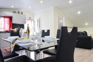a dining room with a glass table and black chairs at Casa da Praia, a Home in Madeira in Ribeira Brava