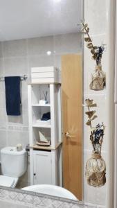 ein Badezimmer mit einem WC und einer Vase mit Blumen in der Unterkunft Costa Brava-St Antoni de Calonge apartament per parelles i famílies petites in Calonge