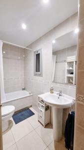 ein Badezimmer mit einem Waschbecken, einer Badewanne und einem WC in der Unterkunft Costa Brava-St Antoni de Calonge apartament per parelles i famílies petites in Calonge