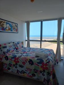 um quarto com uma cama e vista para o oceano em FLAT BEIRA MAR BARRA DE JANGADA RECIFE ANDAR ALTO em Recife