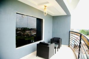 a balcony with a chair and a large window at 247 Luxury Hotel & Apartment Ajah in Lekki
