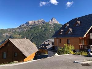 a group of buildings with a mountain in the background at Joli appartement avec terrasse vue sur les montagnes in Uvernet-Fours