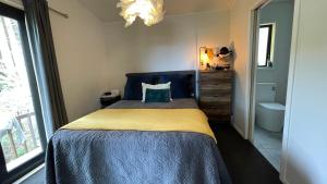 a bedroom with a bed with a blue and yellow blanket at Paihia Central Apartments in Paihia