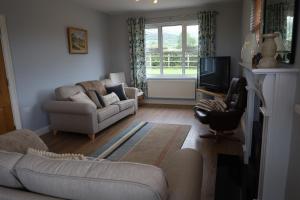 a living room with a couch and a tv at Benbradagh Country Cottage Causeway Coast in Dungiven