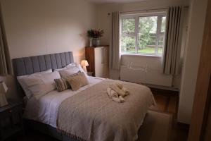 a bedroom with a bed with a stuffed animal on it at Benbradagh Country Cottage Causeway Coast in Dungiven