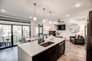 a kitchen with a sink and a living room at River West Ptarmigan Peak Condo - Upscale Riverfront Retreat in Silverthorne