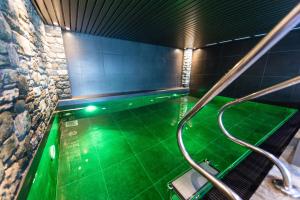a bathroom with a lot of green tiles and a lot of water at Nendaz 4 Vallées & SPA 4* Superior in Nendaz