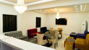 uma sala de espera com cadeiras coloridas e uma mesa em 247 Luxury Hotel & Apartment Ajah em Lekki