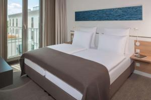 Ένα ή περισσότερα κρεβάτια σε δωμάτιο στο Dorint Hotel Hamburg-Eppendorf